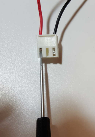 using a small screwdriver to remove a pin from the motor connector